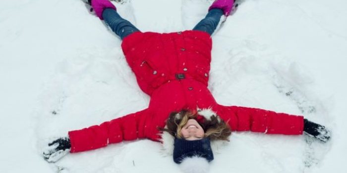 Winter time,cheerful girl having fun in the snow, top view.